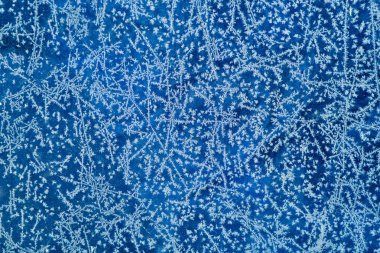 Yeni yıl ve Noel buzlu karlı arka plan gerçek buz kristalleri makroda soğuk mavi tonları ile