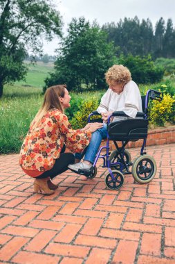 Genç kadın yaşlı kadın bir tekerlekli sandalye olarak söz