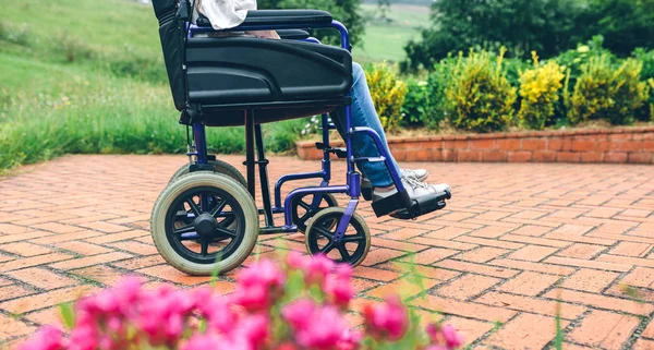 Femme âgée méconnaissable en fauteuil roulant — Photo