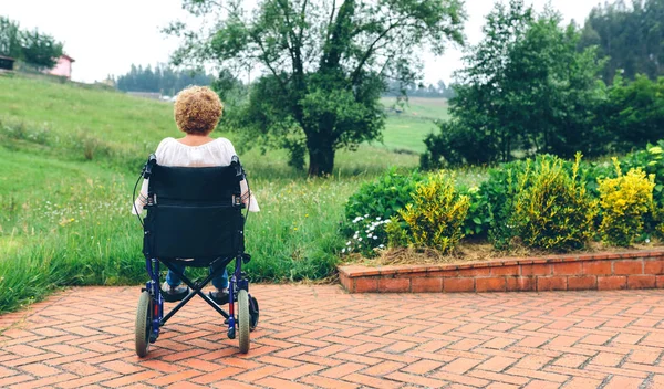 Femme âgée méconnaissable dans un fauteuil roulant — Photo