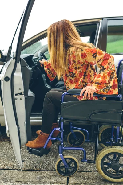 Mujer en silla de ruedas subiendo al coche — Foto de Stock