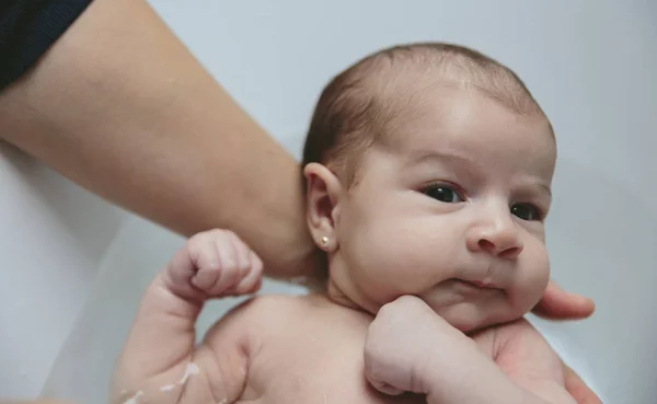 Recém-nascida na banheira realizada por sua mãe — Fotografia de Stock