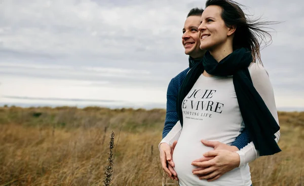 Těhotná s partnerem objímání a drží břicho — Stock fotografie