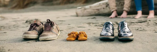 Zapatos de familia en la arena — Foto de Stock