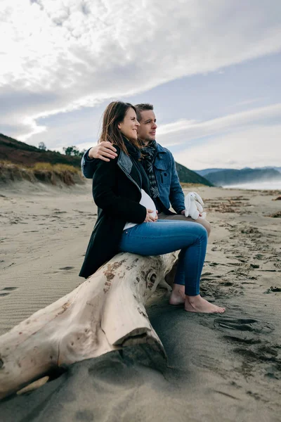 Embarazada en la playa con su pareja — Foto de Stock