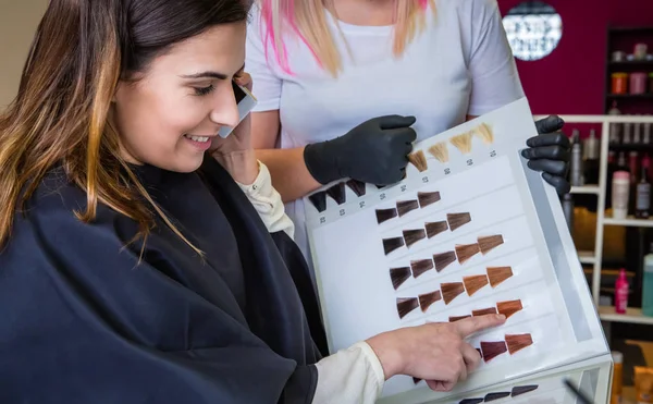 Frau mit Smartphone sieht Haarfärbepalette aus — Stockfoto