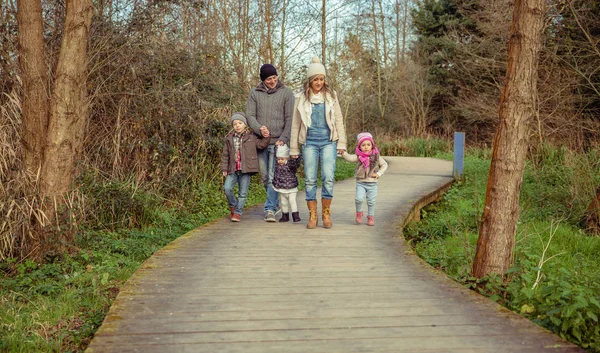 Família feliz andando juntos de mãos dadas na floresta — Fotografia de Stock