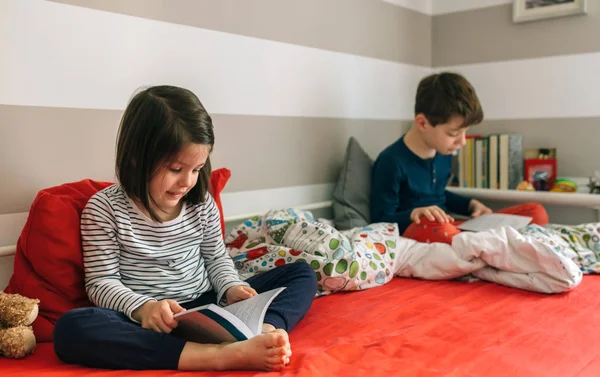 Flicka och pojke läser en bok — Stockfoto