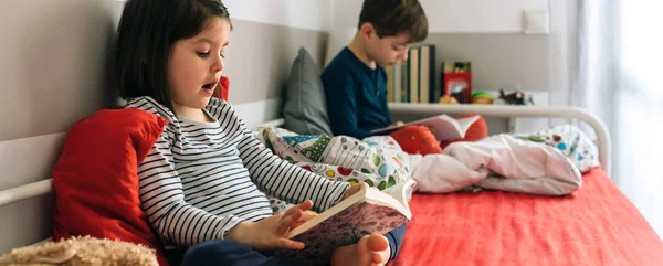 Flicka och pojke läser en bok — Stockfoto