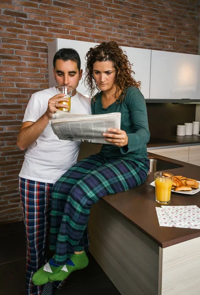 Пара завтракает и читает газету — стоковое фото