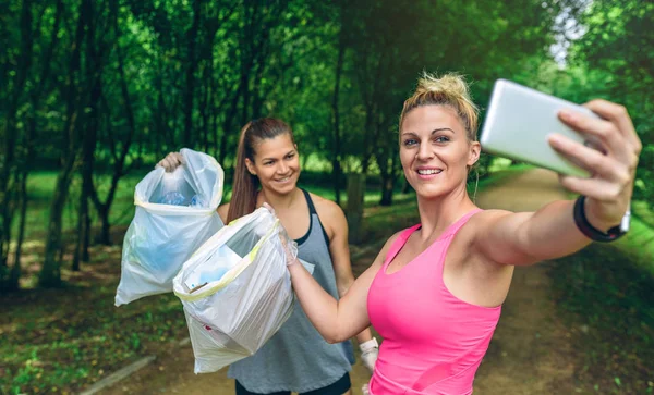 Δύο Κορίτσια Ευτυχισμένη Λαμβάνοντας Μια Selfie Δείχνει Σκουπίδια Σακούλες Μετά — Φωτογραφία Αρχείου