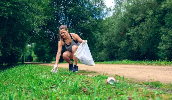 Menina com saco de lixo fazendo plogging — Fotografia de Stock