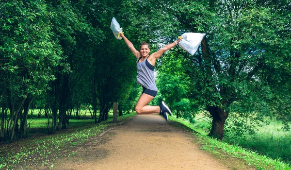 Fille sautant avec des sacs poubelle après avoir labouré — Photo