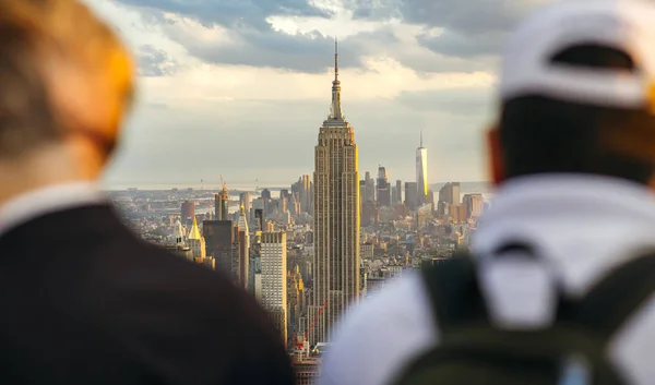 El Empire State Building en Manhattan entre dos hombres irreconocibles en primer plano — Foto de Stock