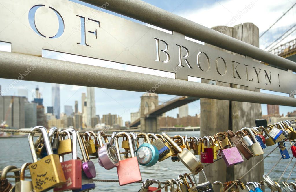 Love locks in fence with Brooklyn Bridge on background