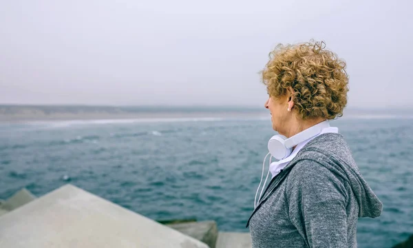 Senior sportswoman looking at the sea — Stock Photo, Image