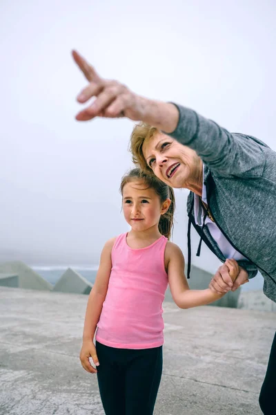 小さな女の子を指す上級スポーツウーマン — ストック写真
