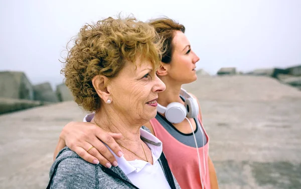 Seniorin und junge Sportlerin schauen weg — Stockfoto