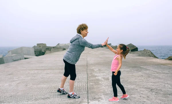 Senior sportswoman y little girl high five —  Fotos de Stock