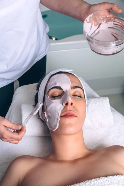 Kosmetolog tillämpa ansiktsmask kvinna i spa — Stockfoto