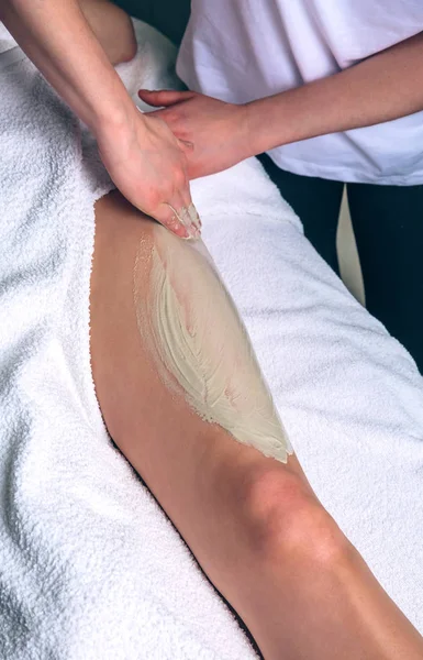 Beautician applying clay treatment in woman legs on spa — Stock Photo, Image