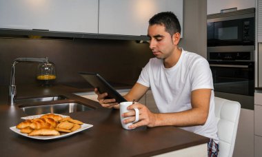 Kahvaltı ve tablet arayan adam