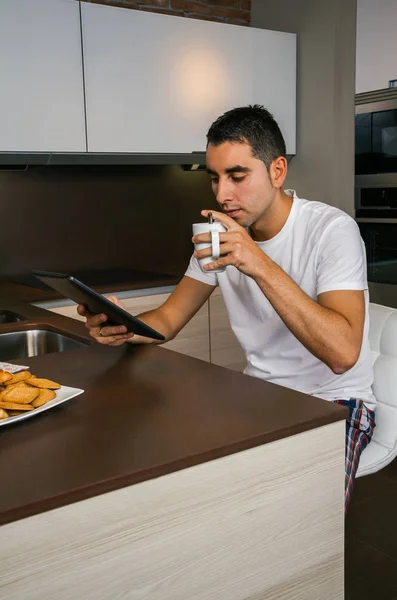 Мужчина завтракает и смотрит планшет — стоковое фото