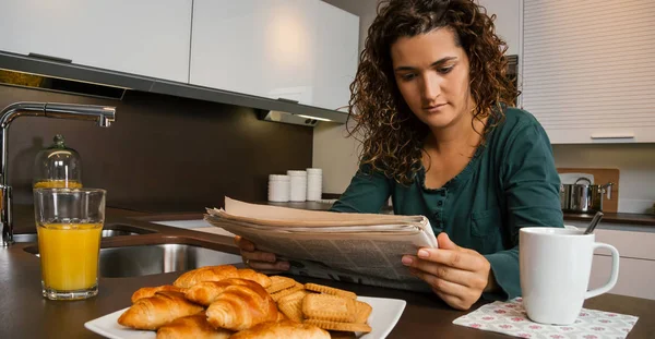 Donna che fa colazione e cerca giornale — Foto Stock