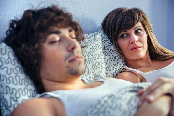 Donna arrabbiata in cerca di giovane uomo che dorme — Foto Stock