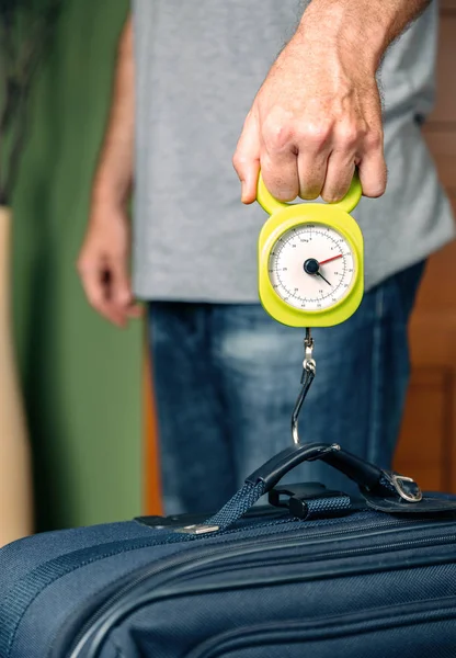 Homem que verifica o peso da bagagem com equilíbrio de ferro — Fotografia de Stock