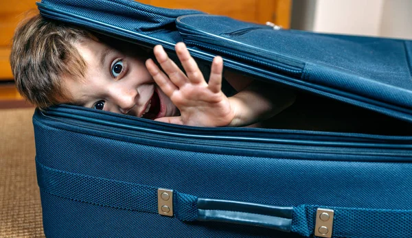 Rolig pojke ler i en resväska — Stockfoto