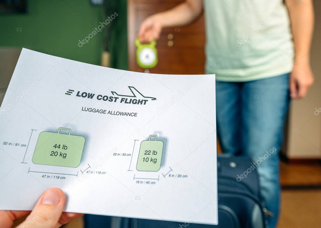 Couple checking luggage weight with steelyard balance