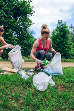 Plogging yapıyor çöp toplama çöp ile çömelme kız çanta
