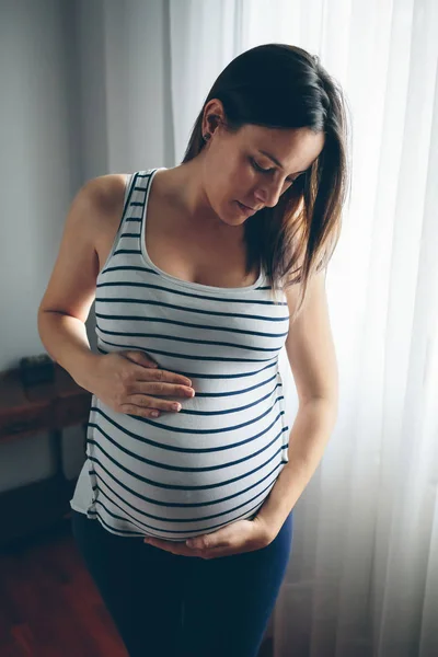 Těhotná žena hledá její břicho — Stock fotografie