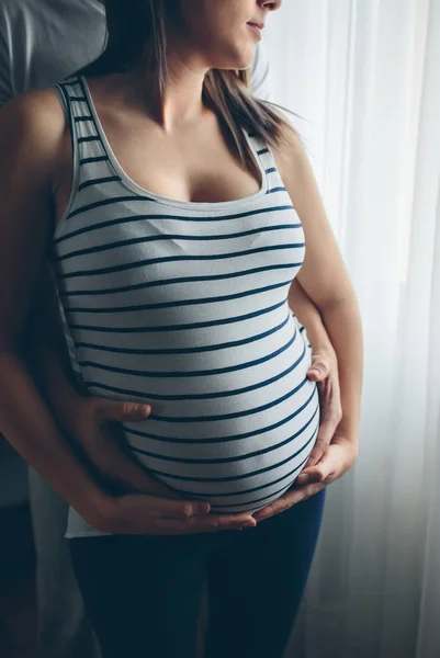 Gravid kvinna omfamnas av maken — Stockfoto