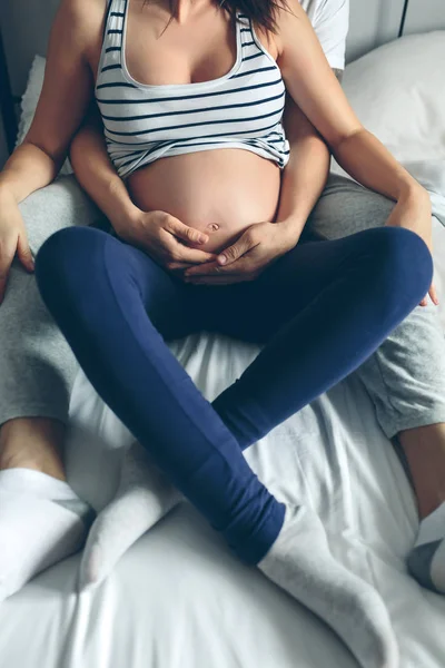 Gravid kvinna omfamnas av maken — Stockfoto