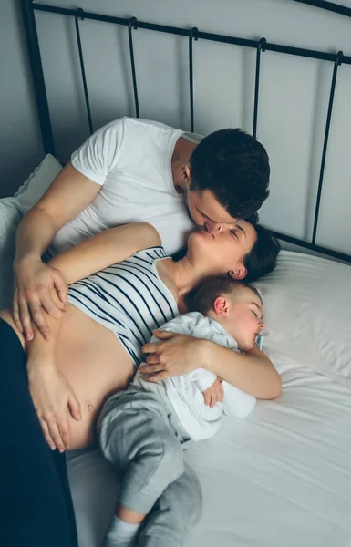 Pregnant kissing her partner with their son — Stock Photo, Image