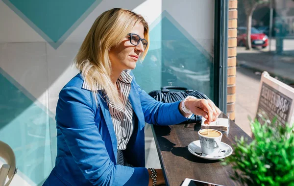 Junge Frau rührt Kaffee an — Stockfoto