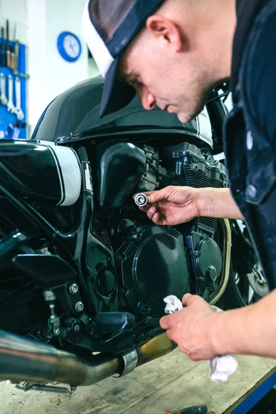 Mechanic repairing customized motorcycle — Stock Photo, Image