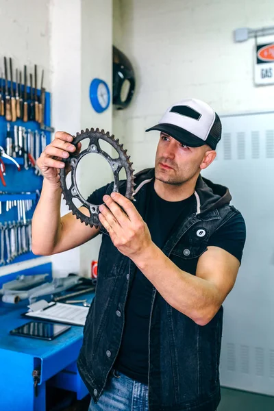 Mechanic reviewing motorcycle sprocket — Stock Photo, Image