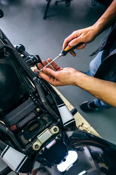 Mechanic repairing customized motorcycle — Stock Photo, Image