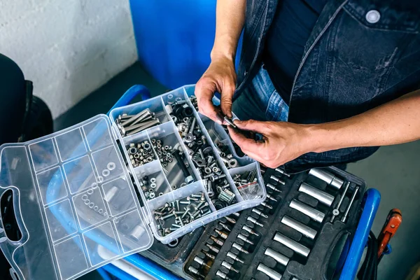 Mechanics hands choosing screws from a tool box — Stock Photo, Image