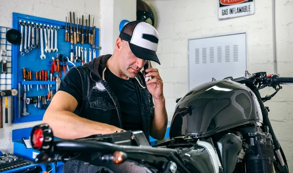 Telefono parlante meccanico durante il fissaggio della moto — Foto Stock