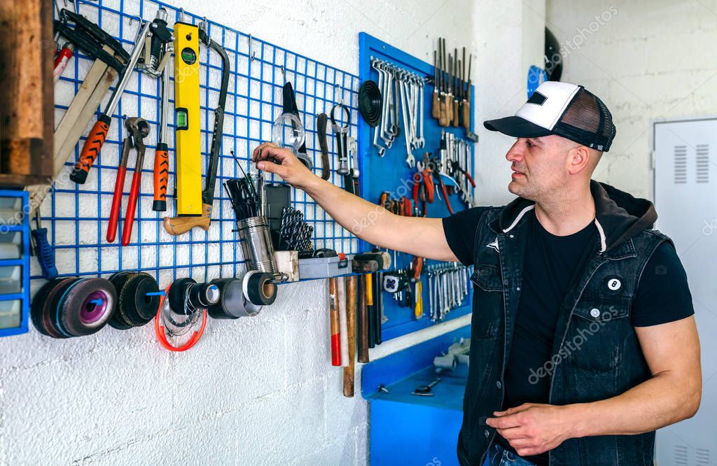 Mechanic in his workshop taking tools