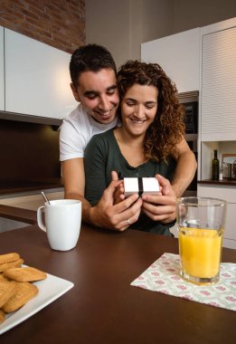 Kucaklayan ve bir hediye kutusu sürpriz kız arkadaşına veren adam