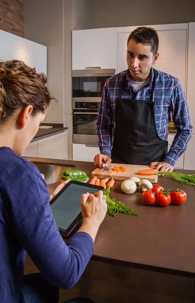 Homem cozinhar e mulher procurando receita em tablet eletrônico — Fotografia de Stock