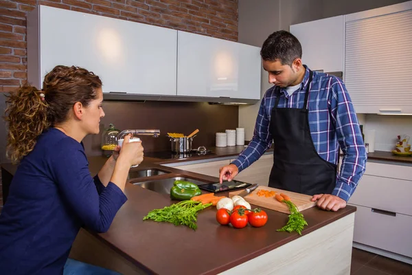 Man in huis keuken op zoek recept met elektronische tablet — Stockfoto