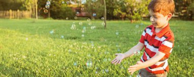 mutlu çocuk parkta sabun köpüğü ile oynarken