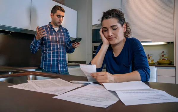 Desperata unga par med skulder granska sina räkningar — Stockfoto