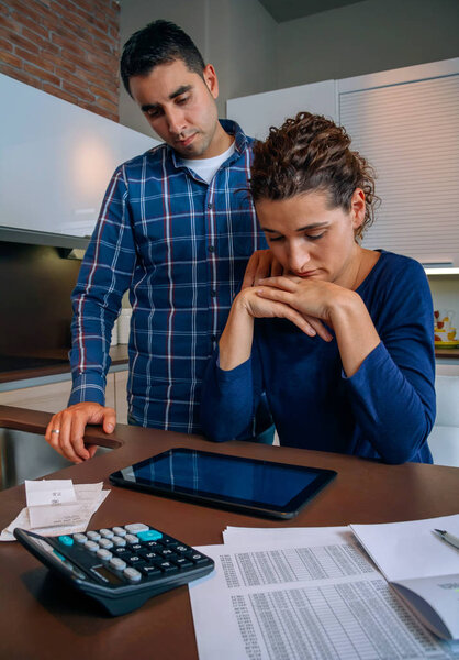 Desperate young woman with debts reviewing the bills